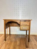 Front view of oak Mission-style desk showing two drawers and leg structure
