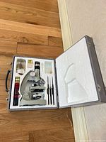 Case open showing microscope and all accessories fitted in styrofoam