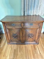 Front view of closed buffet showing drawers, carved doors, finish and hardware