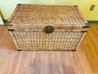 Front view of wicker trunk showing latch and corner caps