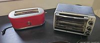 KitchenAid red 2-slice toaster and Black+Decker toaster oven side-by-side