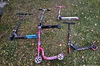 All five scooters laid flat showing deck colours and wheel types