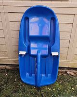 Top view of blue plastic sled showing seating area and hand brakes