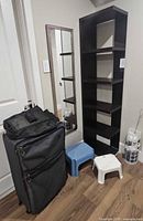Front view of bookcase, mirror, suitcase, stools, bag holder