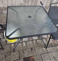 square glass top patio table with metal frame and umbrella hole