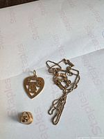 Necklace and three pendants laid out on envelope