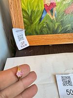 Ring held close showing pink stone and gold setting