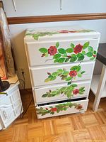 Front view of white dresser showing floral artwork and four drawers