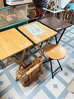 Overview of three standing tables, folded table in wrap, and stool