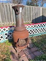 Full view of cast iron chiminea in yard