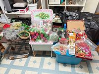 Wide view of all Christmas decorations on tables and in bin