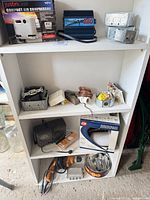 Shelf view with boxed compressor, inverter, junction boxes, GE iron, drill and accessories