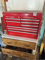 Front view of red Sears/Craftsman tool chest atop wood stand