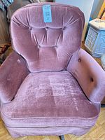 Front view of mauve velvet armchair showing tufted back, seat cushion and casters