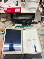 Tablet, open box showing accessories and packaging