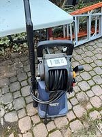 Front view showing Simoniz 1700 PSI unit, hose reel, spray gun attached, blue housing