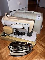 Singer sewing machine with case, foot pedal and cords visible