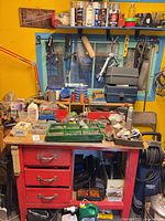 Overall view of workbench, hardware trays, hand tools, wall-mounted items
