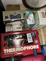 Lot overview showing neck warmer set, glove boxes, and Thermophore box