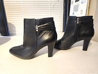 Side view of both boots showing leather, heel height and zipper