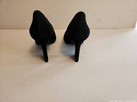 Rear view of both heels showing block heel shape and suede material