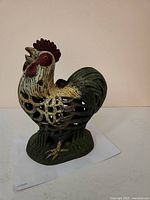 Front view of painted cast iron rooster candle holder