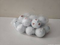 Bagged assortment of 25 white golf balls