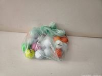 Bag of assorted coloured and white golf balls