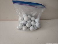 Bag of 25 white golf balls in a clear zipper bag