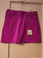 Front of magenta Puma skort with tag visible