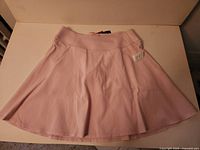 Front view of light pink Puma Pwrshape skort with waistband and flared skirt