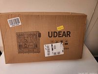 Sealed cardboard box labeled UDEAR with shipping labels
