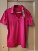 Front view of Nivo berry golf shirt with tags attached