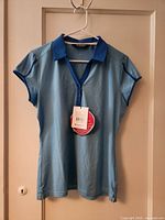Front view of light blue Sunice women’s golf polo shirt with tags attached