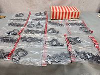 All 20 sealed hardware sets laid out with original striped box visible