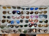 Full overview of all 30 pairs laid out in five rows showing variety of frame shapes and lens colors