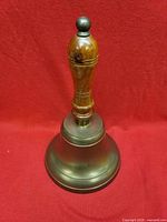 Full view of brass handbell standing upright