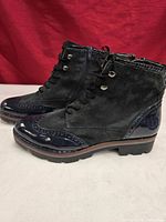 Side view of both boots showing suede upper, patent leather toe/heel, laces