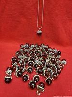 Pile of bead charms with capped loops and necklace visible