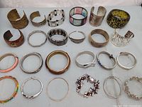 Full lot overview showing approximately 23 bracelets and bangles arranged in rows