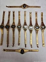 All ten gold-tone digital wristwatches laid out