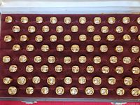 Tray showing multiple rows of gold-tone Om signet rings
