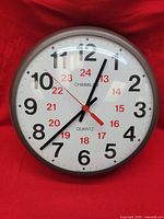 Front view of wall clock showing dual-color numerals and hands