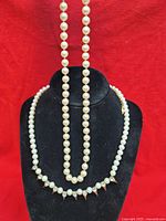 Both necklaces displayed on black bust showing overall designs