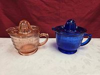 pink and cobalt glass juicer measuring cups assembled with reamer tops