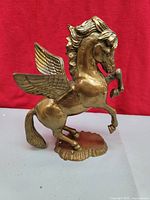 Front left view of solid brass Pegasus statue showing rearing pose, wings and base