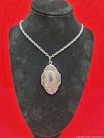 Full view of locket on chain displayed on bust