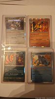 Front view of all four Pokémon cards in sleeves showing names, HP and artwork