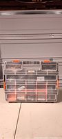 Front view of HDX organizer showing clear lid, multiple compartments filled with fasteners