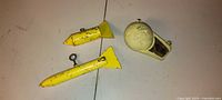 All three downrigger items laid out: Tru Trac planer and two yellow torpedo weights